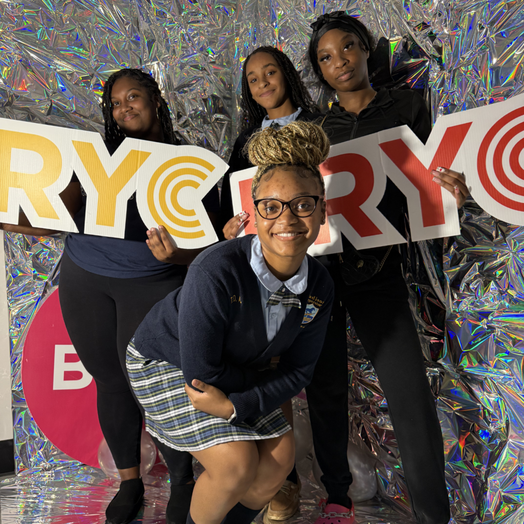 Three Fellows holding BRYC signs during Welcome Week 2026